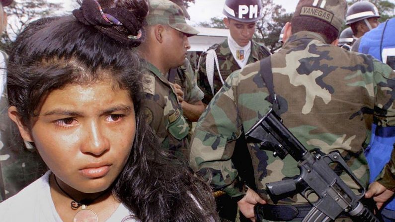 Uma guerrilheira colombiana de 15 anos é resgatada e mantida em 16 de janeiro de 2000 na base da Força Aérea de Apiay, província de Meta, após ser capturada durante confrontos entre soldados colombianos e guerrilheiros das Forças Armadas Revolucionárias da Colômbia (FARC ) (LUIS ACOSTA / AFP / Getty Images)