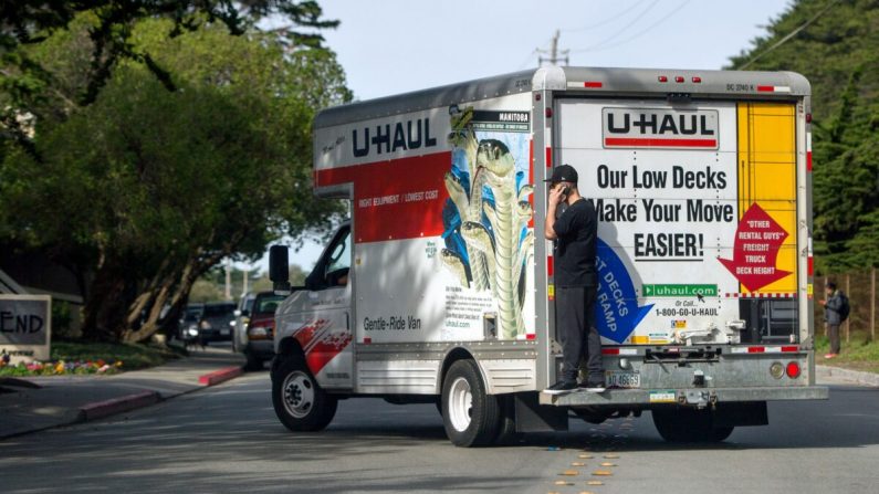 Un hombre habla por su teléfono celular mientras viaja en la parte trasera de un camión en Pacifica, California, el 26 de enero de 2016. (Josh Edelson/AFP/Getty Images)