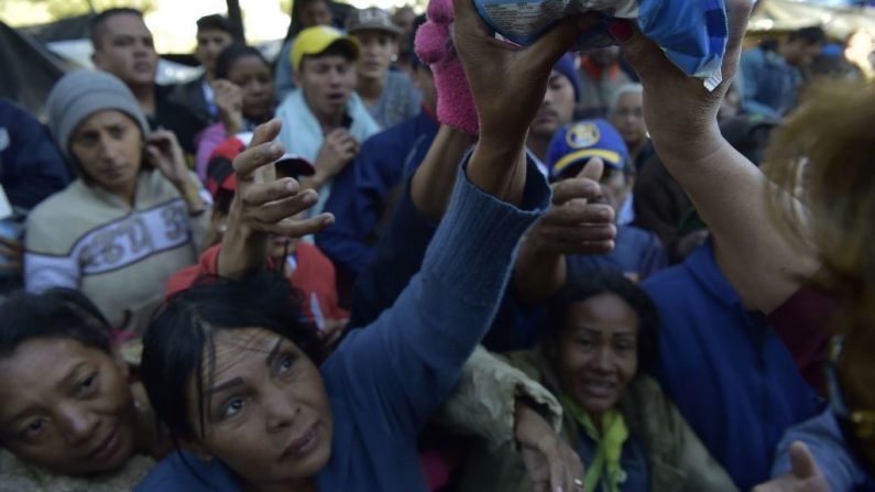 Ciudadanos venezolanos que permanecen en un campamento improvisado junto a la terminal de autobuses en el norte de Quito, buscan donaciones el 9 de agosto de 2018. (RODRIGO BUENDIA/AFP/Getty Images)