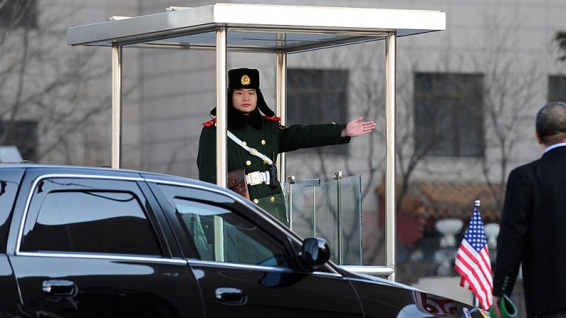 Guardia paramilitar chino señala el camino a seguir al vehículo de la embajada de Estados Unidos que transporta al embajador Jon Huntsman en la Corte Suprema Popular en Beijing el 18 de febrero de 2011.  (FREDERIC J. BROWN/AFP/Getty Images)