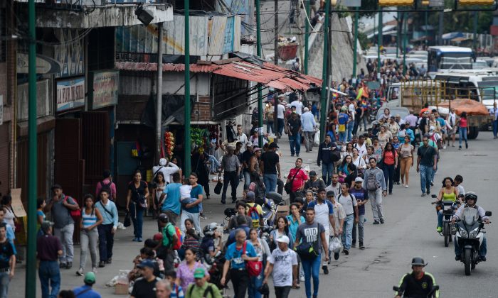 Personas regresan a casa en el barrio de Petare después de que Caracas y otras partes de Venezuela fueron golpeadas por un corte de electricidad masivo el 22 de julio de 2019. (Matias Delacroix/AFP/Getty Images)