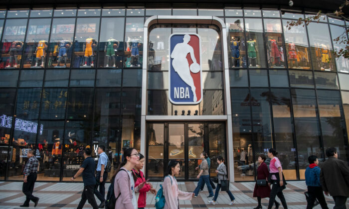 Gente caminando frente a la emblemática tienda de la NBA, en Beijing, China, el 9 de octubre de 2019. (Kevin Frayer/Getty Images)
