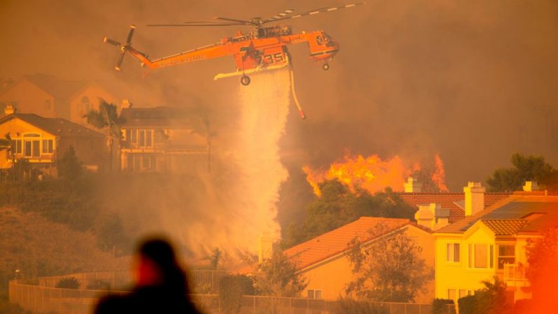 Un helicóptero deja caer agua para ayudar a combatir las llamas en Rancho Porter de Los Ángeles, California, el 11 de octubre de 2019. (JOSH EDELSON/AFP vía Getty Images)
