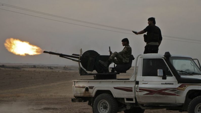 El 14 de octubre de 2019, combatientes sirios respaldados por Turquía disparan un camión con armas pesadas cerca de la ciudad de Tujar, al norte de la ciudad de Manbij, en el norte de Siria, mientras Turquía y sus aliados continúan su asalto a las ciudades fronterizas controladas por los kurdos en el noreste de Siria. (AREF TAMMAWI/AFP vía Getty Images)
