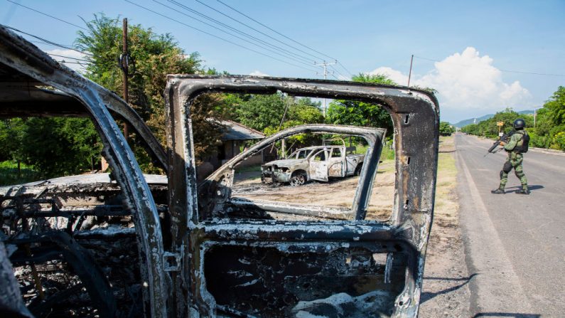 Foto de vehículos policiales incendiados por el Cártel Jalisco Nueva Generación que también mató a 14 policías en una emboscada en la comunidad de Aguililla, en el estado mexicano de Michoacán, el 14 de octubre de 2019.  (ENRIQUE CASTRO/AFP vía Getty Images)

