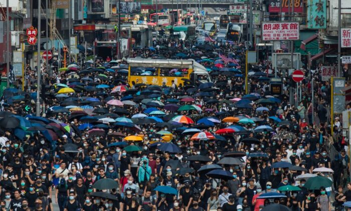 La gente marcha por la carretera principal de Mong Kok mientras participan en una marcha pro-democracia desde Tsim Sha Tsui en el distrito de Kowloon en Hong Kong el 20 de octubre de 2019. (Philip Fong/AFP vía Getty Images)