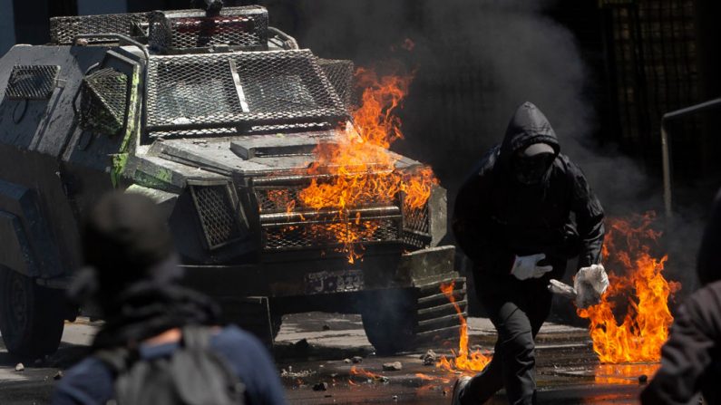 Manifestantes se enfrentan a la policía antidisturbios durante una protesta en Santiago de Chile el 21 de octubre de 2019. (CLAUDIO REYES/AFP vía Getty Images)

