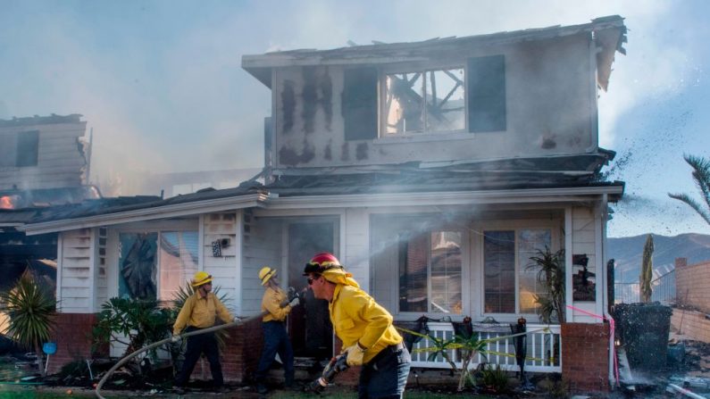 Bomberos trabajan en una casa en llamas durante el incendio en Agua Dulce, cerca de Santa Clarita, California, el 25 de octubre de 2019. (MARK RALSTON/AFP vía Getty Images)
