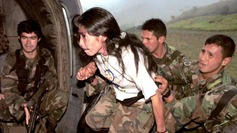 Miembros del ejército colombiano ayudan a una niña a subir a un helicóptero el 20 de diciembre de 2000, que era guerrillero de las FARC después de ser capturada cerca de Bucaramanga, Colombia. UNICEF ha criticado a las FARC por su uso de niños en actividades guerrilleras. (STR /AFP/Getty Images)