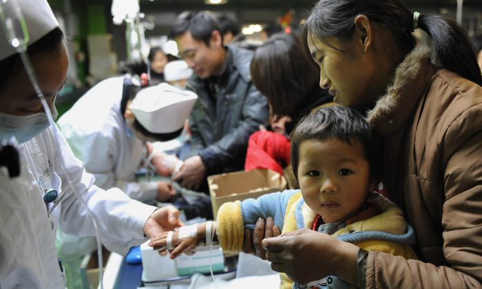 Un grupo de niños chinos acompañados por sus padres recibe tratamiento para la gripe en un hospital de Hefei, en la provincia de Anhui, en el este de China, el 8 de enero de 2010 (STR/AFP/Getty Images).
