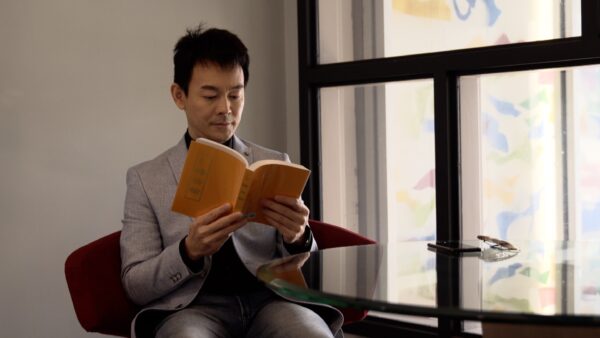 Ryan Jiang leyendo Zhuan Falun, el libro principal de Falun Dafa. (NTD Televisión)