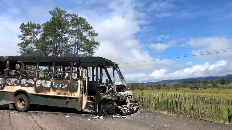 Vista general este lunes de un autobús incendiado para bloquear el acceso a los poblados de Tocombo y Los Reyes, en occidental estado de Michoacán (México). EFE/STR
