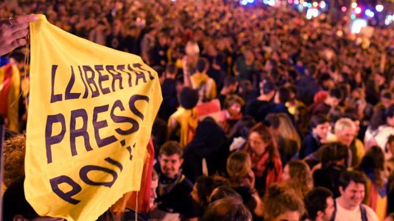 Uma mulher segura uma faixa exigindo "liberdade para presos políticos" durante uma "festa desobediente e esportiva" pró-independência, convocada pelos Comitês de Defesa da República (CDR) em Barcelona em 17 de outubro de 2019. - Separatistas catalães estavam de volta às ruas hoje, novamente, com os estudantes se reunindo ao iniciar uma greve de dois dias e milhares mais pressionando com uma longa marcha pelo país em direção a Barcelona (Foto por LLUIS GENE / AFP via Getty Images)