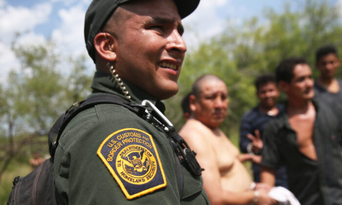 Agentes de la Patrulla Fronteriza de los Estados Unidos vigilan a los inmigrantes indocumentados después de ponerlos bajo custodia el 22 de julio de 2014 cerca de Falfurrias, Tex. (John Moore/Getty Images)