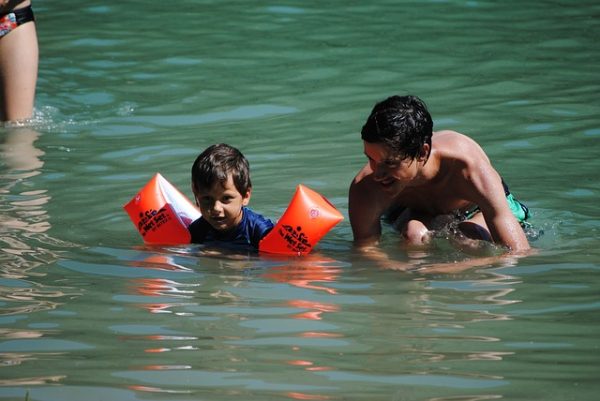 papá enseñando a hijo a nadar