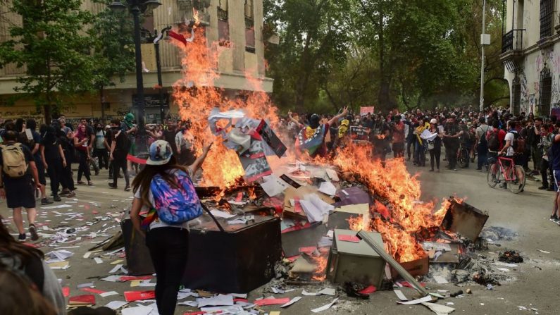 Los manifestantes queman documentos y objetos después de saquear una sucursal de un banco en Santiago el 25 de octubre de 2019, una semana después de que comenzara la violencia. (MARTIN BERNETTI / AFP / Getty Images)