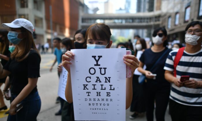 Una manifestante sostiene un cartel, imitando una tabla optométrica que dice "puedes matar al soñador pero no puedes matar al sueño", durante un manifestación en Chater Garden, Hong Kong, el 2 de octubre de 2019. (Mohd Rasfan/AFP via Getty Images)
