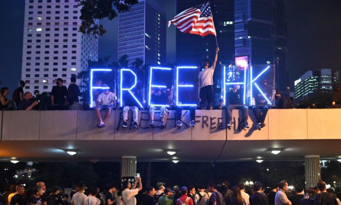 Un letrero de luz que dice "Free HK" es vista mientras la gente participa en un mitin de profesionales de la salud en el distrito central de Hong Kong el 26 de octubre de 2019. (Philip Fong/AFP vía Getty Images)