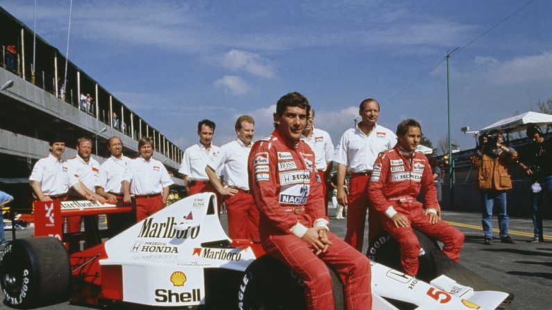 O piloto de corrida brasileiro Ayrton Senna (1960-1994, centro) e seu companheiro de equipe austríaco Gerhard Berger (à direita) posam com o restante da equipe McLaren no Grande Prêmio do México no circuito da Cidade do México, 24 de junho de 1990 (Foto por Sutton / Getty Images )