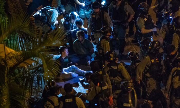 La policía detiene a manifestantes y estudiantes después de que intentaron huir fuera del campus de la Universidad Politécnica de Hong Kong en el distrito de Hung Hom en Hong Kong, el 19 de noviembre de 2019. (Billy H.C. Kwok/Getty Images)