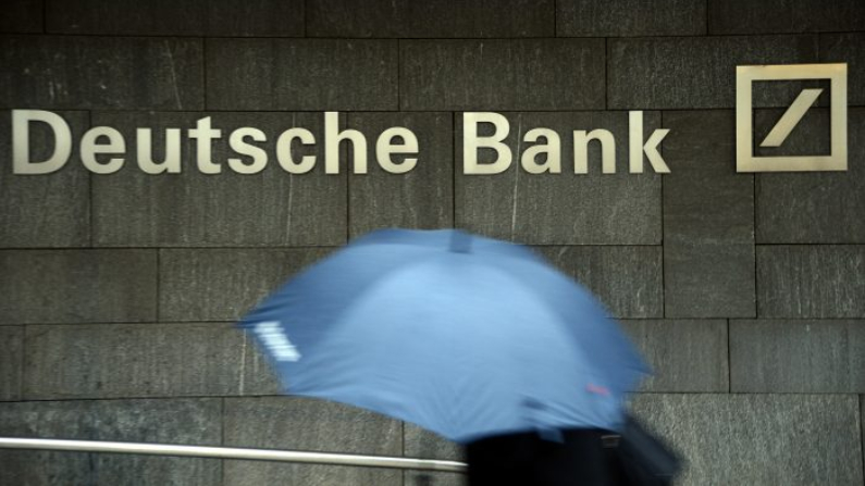 Una mujer con paraguas pasa un logotipo de Deutsche Bank el 29 de enero de 2013 en Frankfurt am Main, Alemania. (Thomas Lohnes / Getty Images)