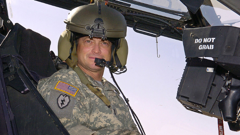 BASE OPERATIVA DE CONTINGENCIA, IRAq. El actor Gary Sinise se sienta en un helicóptero Apache del Ejército de los EE.UU. durante un recorrido por la línea de vuelo el 21 de mayo de 2007 en la Base de Operaciones de Contingencia Speicher, Irak. Sinise está en una gira de encuentros y saludos patrocinada por la USO para levantar la moral entre las fuerzas estadounidenses en la zona. (Mike Theiler/USO vía Getty Images)
