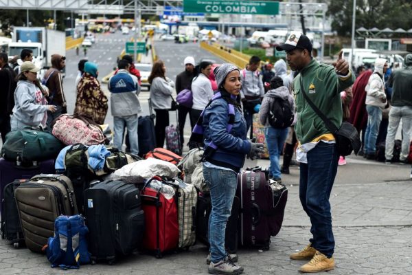 Migrantes venezolanos esperan afuera de la oficina de migraciones colombiana en el Puente Internacional Rumichaca, en la frontera entre Ipiales, Colombia y Tulcan, Ecuador, el 20 de agosto de 2018. (Luis Robayo / AFP / Getty Images)