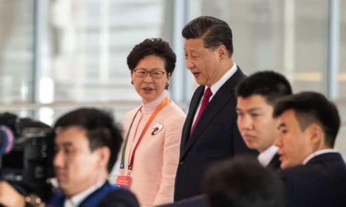La jefa ejecutiva de Hong Kong, Carrie Lam, y el líder chino Xi Jinping, llegan a la ceremonia de inauguración del puente Hong Kong-Zhuhai-Macau en la terminal del puerto de Zhuhai el 23 de octubre de 2018. (FRED DUFOUR/AFP vía Getty Images)
