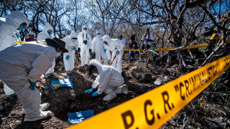 El personal forense del Fiscal General de México trabaja en la exhumación de restos humanos encontrados durante las actividades de la cuarta Brigada Nacional de Búsqueda, en Huitzuco de los Figueroa, estado de Guerrero, México, el 21 de enero de 2019. (PEDRO PARDO / AFP / Getty Images)