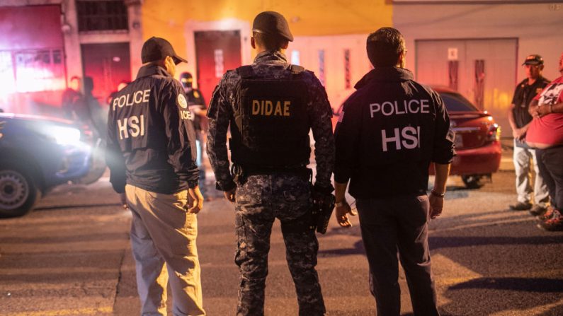 Agentes del ICE con Investigaciones de Seguridad Nacional de los Estados Unidos (HSI) y un policía guatemalteco (C) se encuentran en el lugar de una redada matutina donde un presunto traficante de personas (R) fue detenido el 29 de mayo de 2019 en la Ciudad de Guatemala.(John Moore/Getty Images)