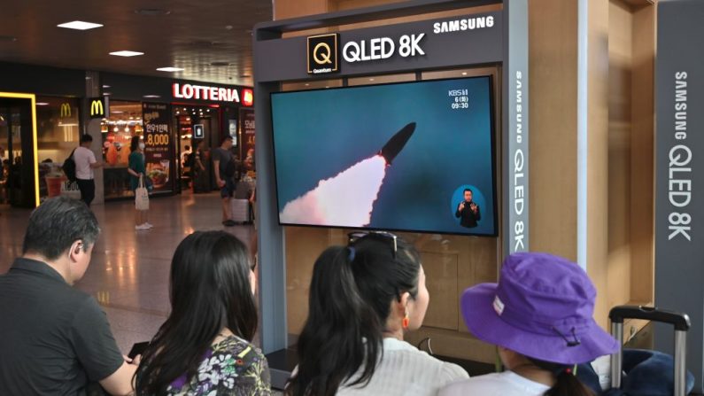 El 6 de agosto de 2019, en una estación de ferrocarril de Seúl, la gente ve un noticiero de televisión que muestra un archivo del lanzamiento de los misiles de Corea del Norte. (JUNG YEON-JEON/AFP vía Getty Images)
