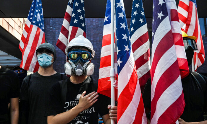 Los estudiantes sostienen la bandera de los Estados Unidos y cantan el Star-Spangled Banner en la Universidad de Hong Kong (HKU) en Hong Kong el 20 de septiembre de 2019, mientras se reúnen para que el Congreso de los Estados Unidos apruebe la Ley de Derechos Humanos y Democracia de Hong Kong. (Foto de Anthony WALLACE / AFP) (El crédito de la foto debe leer ANTHONY WALLACE / AFP a través de Getty Images)