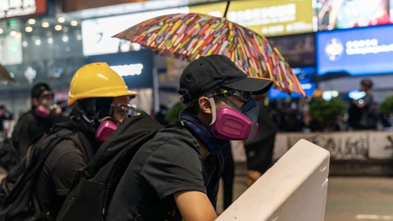 Los manifestantes pro-democracia reaccionan al tiempo que la policía dispara gas lacrimógeno durante una manifestación el 20 de octubre de 2019 en Hong Kong, China. (Foto de Anthony Kwan/Getty Images)