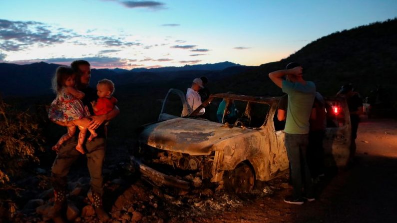 Miembros de la familia LeBarón miran el auto quemado donde parte de los nueve miembros asesinados de la familia fueron asesinados y quemados durante una emboscada en Bavispe, montañas de Sonora, México, el 5 de noviembre de 2019. 
 (Herika Martinez/AFP/ Getty Images)