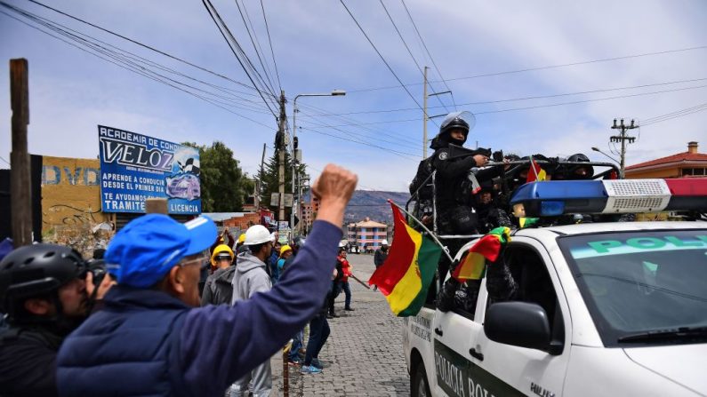 La gente saluda a los policías que retiraron su apoyo al expresidente Evo Morales mientras patrullan las calles de La Paz el 11 de noviembre de 2019. (RONALDO SCHEMIDT/AFP vía Getty Images)
