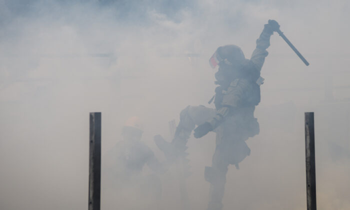 La policía golpea a un manifestante después de intentar escapar del campus de la Universidad Politécnica de Hong Kong en el distrito Hung Hom de Hong Kong, el 18 de noviembre de 2019. (ANTHONY WALLACE/AFP vía Getty Images)
