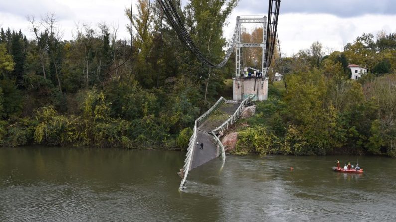 Los equipos de rescate navegan cerca de un puente colgante que se derrumbó el 18 de noviembre de 2019 en Mirepoix-sur-Tarn, cerca de Toulouse, en el suroeste de Francia. (Eric Cabanis / AFP / Getty Images)