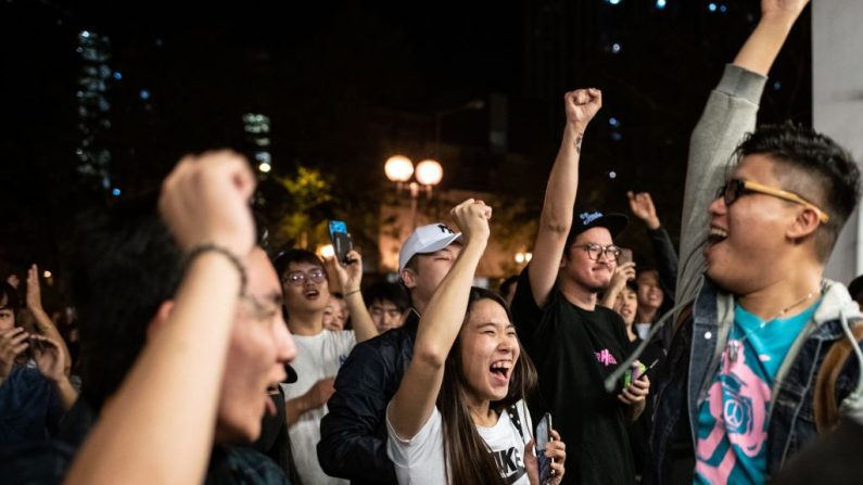Los partidarios pro-democracia cantan mientras celebran la derrota del candidato pro-Beijing Junius Ho en las elecciones del Consejo de Distrito en el distrito de Tuen Mun de Hong Kong, a primeras horas del 25 de noviembre de 2019. (Foto de PHILIP FONG/AFP vía Getty Images)