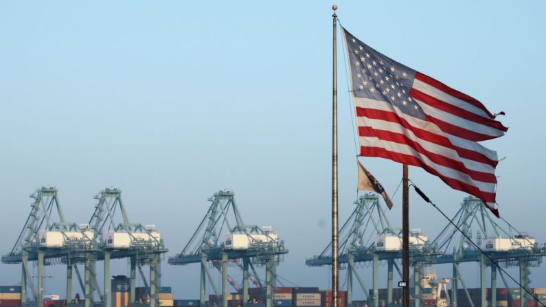 California, una bandera de los Estados Unidos ondea cerca de contenedores apilados en el Puerto de Los Ángeles, el puerto más concurrido de la nación, el 7 de noviembre de 2019. (Mario Tama/Getty Images)