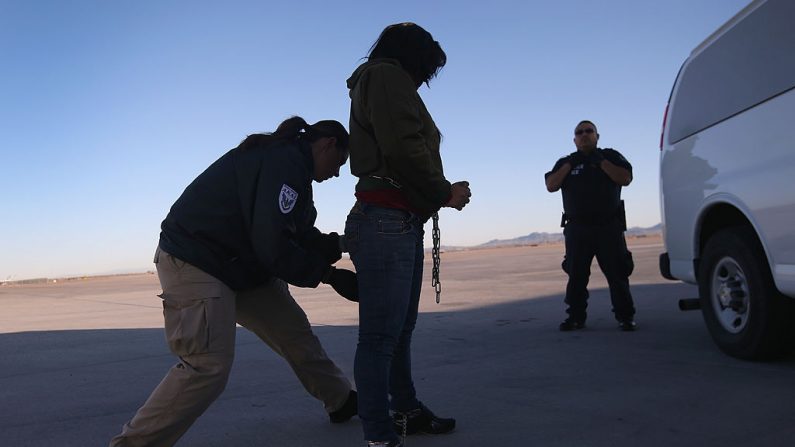 Un contratista de seguridad registra a una detenida de inmigración de Honduras antes de un vuelo de deportación a San Pedro Sula, Honduras, el 28 de febrero de 2013 en Mesa, Arizona (EE.UU.). (John Moore/Getty Images)