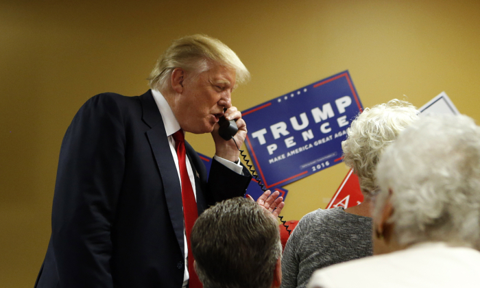 El candidato presidencial Donald Trump habla por teléfono junto a voluntarios de una cabina telefónica antes de una manifestación en el Centro Celular de EE. UU. U.S. de Asheville, Carolina del Norte, el 12 de septiembre de 2016. (Brian Blanco/Getty Images)