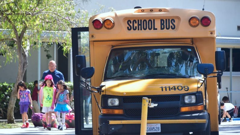 Los niños pasan junto a un autobús escolar en Monterey Park, California, el 28 de abril de 2017. (FREDERIC J. BROWN/AFP vía Getty Images)