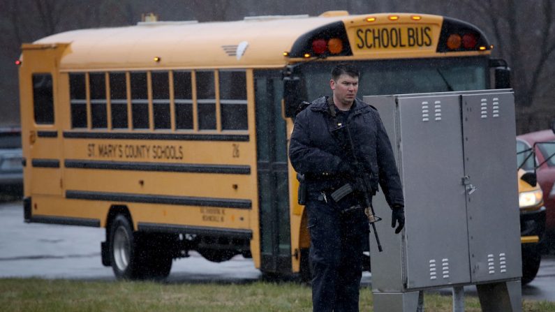 Un agente de seguridad fuertemente armado hace guardia mientras los estudiantes de una escuela son evacuados después de un tiroteo en Leonardtown, Maryland, el 20 de marzo de 2018. (Foto de Win McNamee/Getty Images)