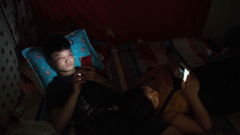 Imagen ilustrativa de jóvenes usando sus teléfonos celulares antes de dormir. (NICOLAS ASFOURI/AFP vía Getty Images)