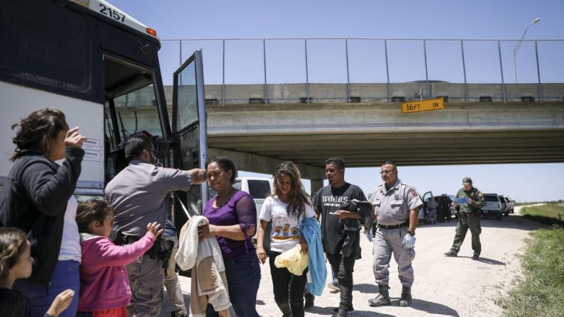 Un gran grupo de extranjeros ilegales sube a un autobús con destino a las instalaciones de procesamiento de la Patrulla Fronteriza, después de haber sido detenidos por la Patrulla Fronteriza cerca de McAllen, Texas, el 18 de abril de 2019. (Charlotte Cuthbertson/La Gran Época)