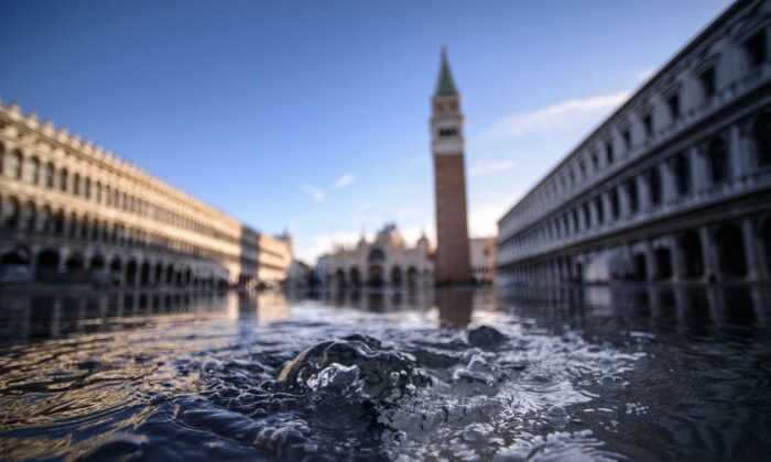 A água borbulha de um bueiro na Praça de São Marcos, inundada em Veneza, em 14 de novembro de 2019 (Filippo Monteforte / AFP via Getty Images)