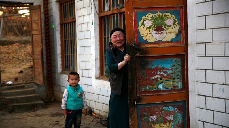 Una mujer y un niño de la minoría étnica uigur posan en la puerta de su casa en Turpan, la Región Autónoma Uigur de Sinkiang, en China. EFE/ How Hwee Young/Archivo