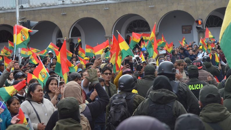 Un grupo de policías se repliega este sábado a su unidad en la ciudad de Oruro (Bolivia). Unidades de la Policía Boliviana se han amotinado en sus comisarías en varias partes del país, en desacuerdo con la actuación del presidente Evo Morales en las crisis que atraviesa Bolivia desde las pasadas elecciones.  (EFE/Emilio Castillo)