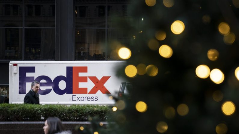 Peatones pasan junto a un camión de FedEx en la ciudad de Nueva York en diciembre de 2018. (Drew Angererer/Getty Images)