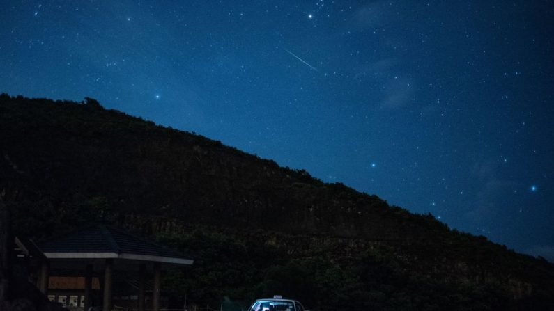 Imagen ilustrativa de un meteorito cruzando el cielo durante la lluvia anual de meteoritos de Perséidas en la presa este del embalse de High Island en Hong Kong. (PHILIP FONG/AFP vía Getty Images)